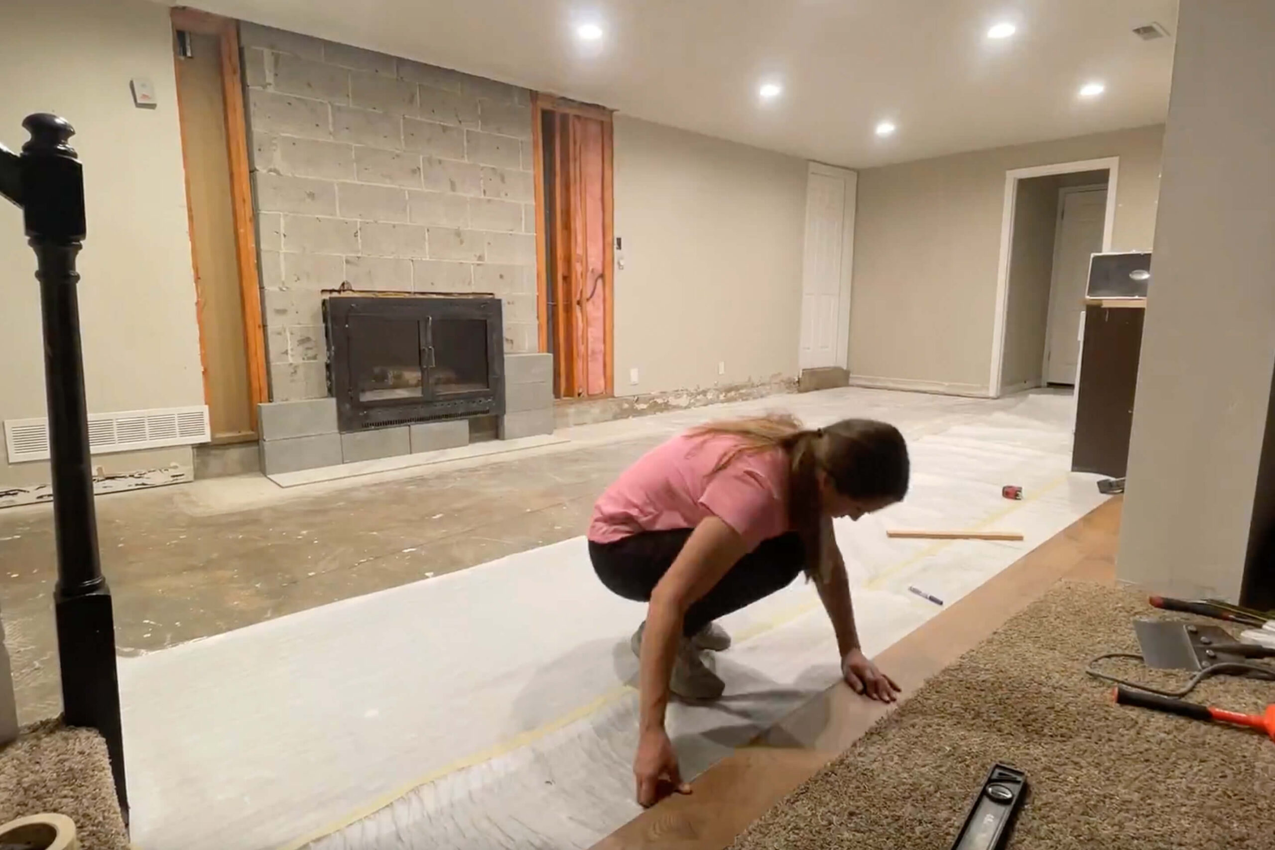 Laying laminate flooring in a kitchen remodel.